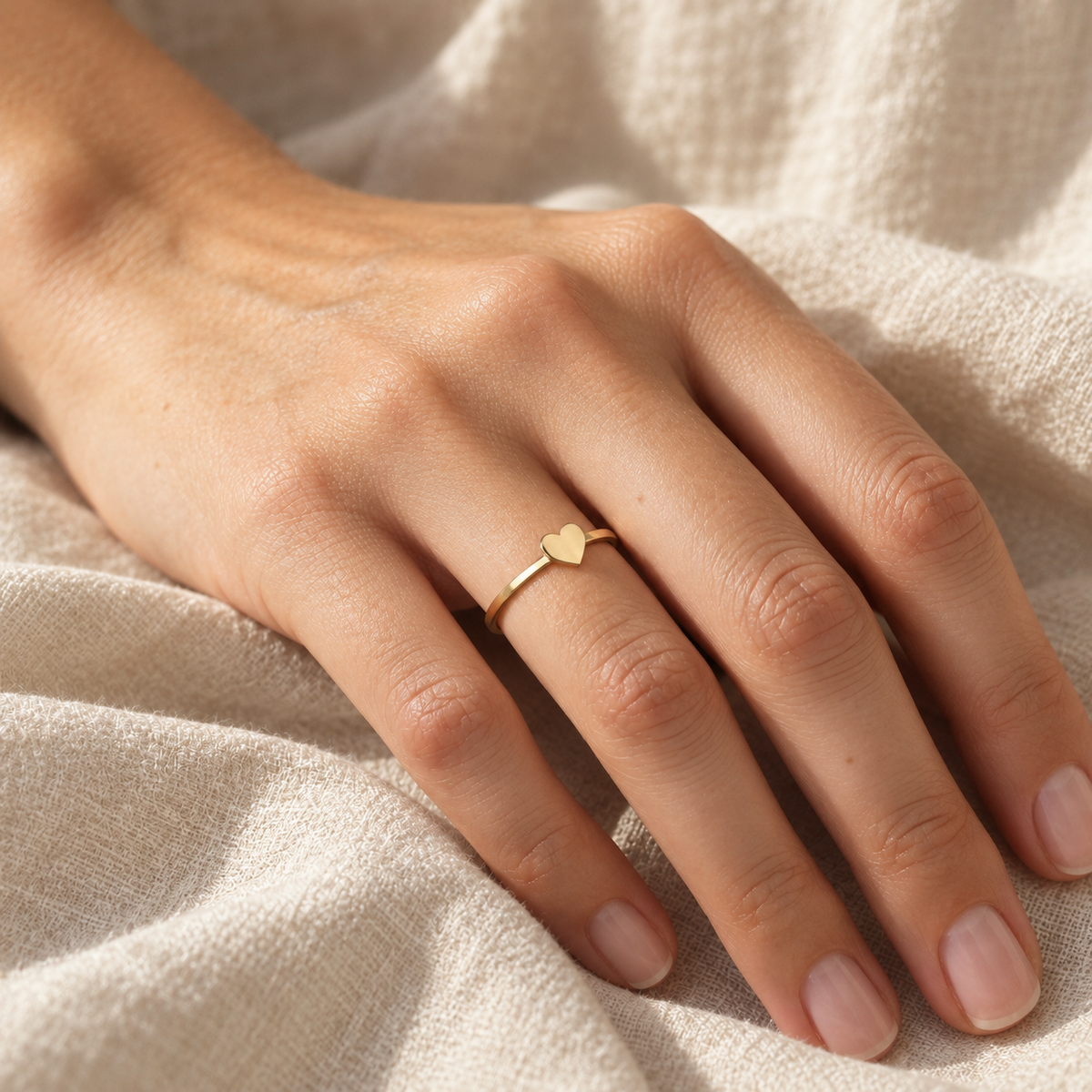 Elena Herzring an einer Hand auf hellem Leinen